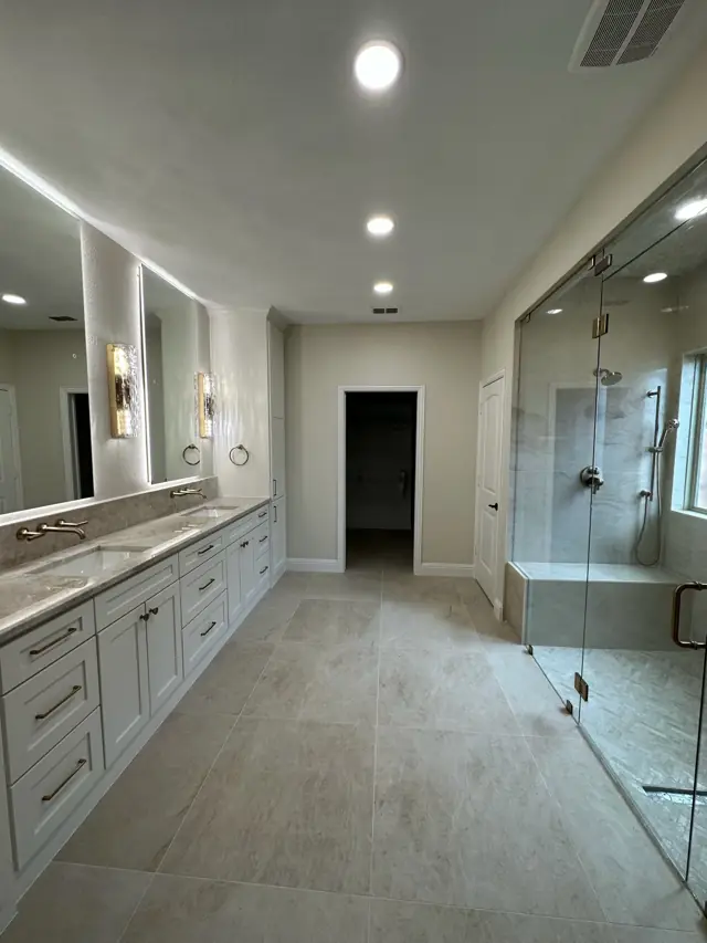 Primary bath with a long vanity and glass-enclosed shower