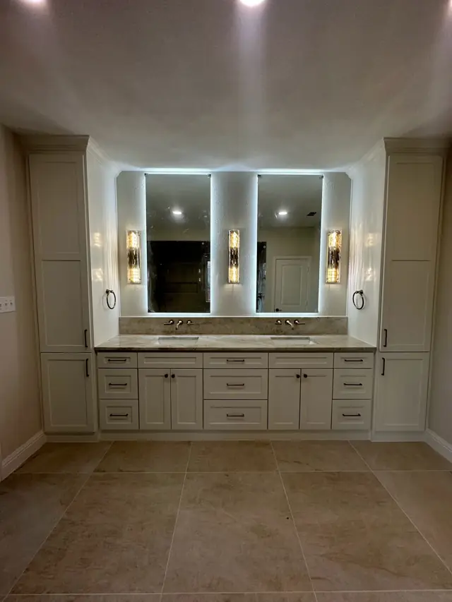 Vanity with backlit mirrors between tall cabinets