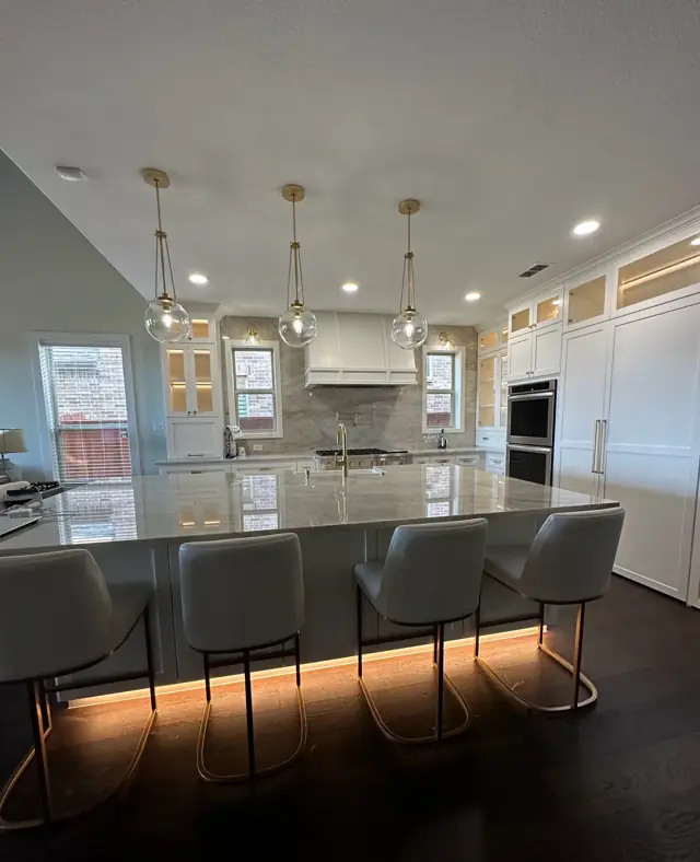 Large quartzite island with bar seating and a glowing toe-kick
