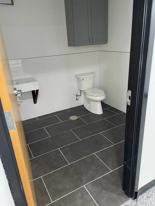 Restroom with dark tile floor