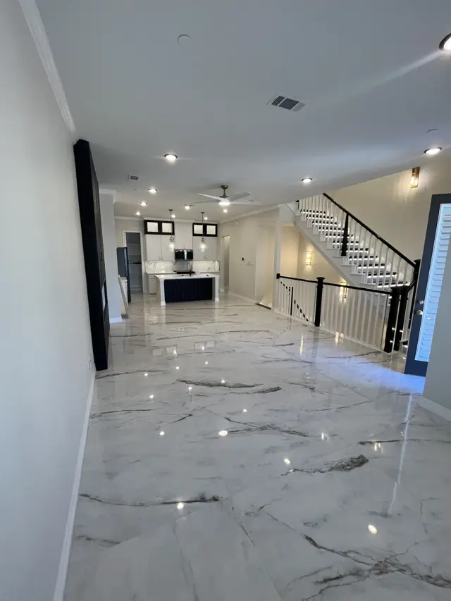 Open townhome living area with a staircase and marble-look floors