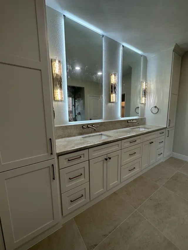 White shaker double vanity with backlit mirrors and wall-mount faucets