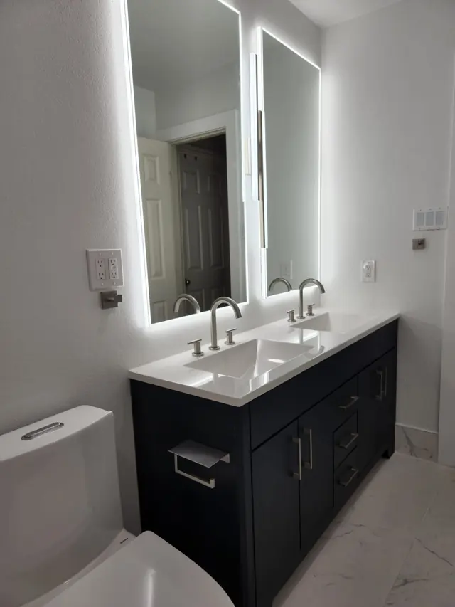 Navy double vanity with backlit mirrors